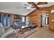 Comfortable living room with wood paneled walls, ceiling fan, and stone fireplace with a mantle at 102 Bascomb Drive Dr, Woodstock, GA 30189