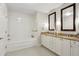 Bright bathroom featuring double vanity, granite countertops, and a soaking tub with white tile surround at 2795 Peachtree Ne Rd # 703, Atlanta, GA 30305