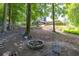 Wooded backyard featuring a fire pit with chairs and a stone path leading up to the house at 3365 Sweetwater Dr, Cumming, GA 30041