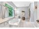 Bright bathroom featuring a soaking tub below a window, providing natural light and a serene atmosphere at 3365 Sweetwater Dr, Cumming, GA 30041