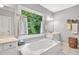 Bright bathroom featuring a garden tub, natural light from large window, and double vanity at 3365 Sweetwater Dr, Cumming, GA 30041