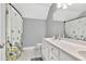 Bathroom featuring an elongated vanity, double sinks, and floral shower curtain at 3365 Sweetwater Dr, Cumming, GA 30041
