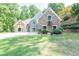 Charming home with stone and blue siding, complemented by a well-manicured lawn and landscaped hillside at 3365 Sweetwater Dr, Cumming, GA 30041