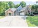 Inviting two-story home with stone accents, blue siding, lush lawn, and convenient two-car garage at 3365 Sweetwater Dr, Cumming, GA 30041