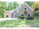 Charming home with stone and blue siding, complemented by a well-manicured lawn and landscaped hillside at 3365 Sweetwater Dr, Cumming, GA 30041