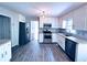 Bright kitchen features white cabinets, stainless steel appliances, and wood look tile flooring at 3460 Ebenezer Rd, Marietta, GA 30066