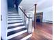 View of staircase leading to an open living room with exposed post beam and stone fireplace at 3460 Ebenezer Rd, Marietta, GA 30066