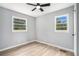 Empty bedroom with hardwood floors, neutral gray walls, a ceiling fan and two large windows at 2621 Walton Sw Way, Marietta, GA 30060