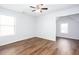 Bright bedroom with a ceiling fan, hard wood floors, and natural light from two windows at 264 Ascott Ln, Woodstock, GA 30189