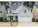 Charming two-story home with gray brick, white siding, manicured lawn and a two car garage at 264 Ascott Ln, Woodstock, GA 30189