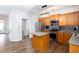 Open kitchen with stainless steel appliances, wood cabinets, an island and sleek countertops at 264 Ascott Ln, Woodstock, GA 30189