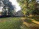 View of back of home from the yard with a deck and lots of shade trees at 4720 Fowler Cir, Acworth, GA 30101