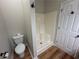Corner shower and toilet are presented next to a closed door with black knob hardware at 4720 Fowler Cir, Acworth, GA 30101