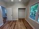 Well-lit bedroom with spacious closet, window overlooking trees, and stylish wood-look floors at 4720 Fowler Cir, Acworth, GA 30101