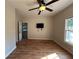 Bedroom with wood-look flooring, ceiling fan, window overlooking backyard, and TV mounted on the wall at 4720 Fowler Cir, Acworth, GA 30101