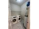 Laundry room with washer, dryer, and water heater, complemented by tile flooring and wire rack at 4720 Fowler Cir, Acworth, GA 30101