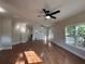 Bright and airy living room with hardwood floors, ceiling fan, and large windows overlooking the landscaped backyard at 4720 Fowler Cir, Acworth, GA 30101