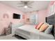 A bedroom with pink walls, a ceiling fan, a large window, a bed, and dresser at 4992 Lower Elm St, Atlanta, GA 30349