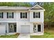 Charming two-story townhome featuring a one-car garage, a covered entry, and stylish black shutters at 4992 Lower Elm St, Atlanta, GA 30349