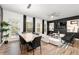 Open-concept living space with modern light fixtures, sleek black accents, and ample seating near a bright window at 4992 Lower Elm St, Atlanta, GA 30349