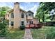 Charming home exterior featuring a stone chimney, manicured lawn and a spacious backyard at 4335 Burgomeister Pl, Snellville, GA 30039