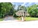 Well-maintained home with a driveway, lush lawn, mature trees, and beautiful stone details at 4335 Burgomeister Pl, Snellville, GA 30039