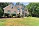 Charming two-story home featuring a manicured lawn, mature trees, and stone accents at 4335 Burgomeister Pl, Snellville, GA 30039