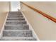 Carpeted staircase with wooden handrail leading to the upper level of the home at 4335 Burgomeister Pl, Snellville, GA 30039