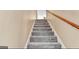 Carpeted staircase with wood handrail, providing access to the upper level of the home at 4335 Burgomeister Pl, Snellville, GA 30039