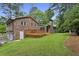 Expansive backyard with lush green grass, a brick house, and a wooden deck at 687 Monticello Se Way, Marietta, GA 30067