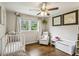 Cozy bedroom featuring hardwood floors, a ceiling fan, and a comfortable chair with lots of light from the windows at 687 Monticello Se Way, Marietta, GA 30067