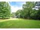 Overhead backyard view, showcasing mature trees, deck, green lawn, and fenced perimeter at 13789 Woolsey Rd, Hampton, GA 30228