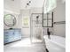 Bright bathroom with a walk-in glass shower, soaking tub, and a blue vanity at 13789 Woolsey Rd, Hampton, GA 30228