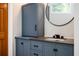 Bathroom vanity with grey countertop and a black round mirror at 13789 Woolsey Rd, Hampton, GA 30228