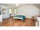 Spacious bedroom with wood floors, a white iron bed frame and a decorative vanity with a mirror at 13789 Woolsey Rd, Hampton, GA 30228