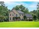 Charming two-story brick home with a well-manicured lawn and mature trees at 13789 Woolsey Rd, Hampton, GA 30228