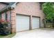 A spacious three-car garage made of brick with white doors at 13789 Woolsey Rd, Hampton, GA 30228