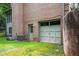 Rear of property showing a one-car garage with a brick facade and lush lawn at 13789 Woolsey Rd, Hampton, GA 30228