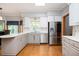 Updated kitchen boasting stainless steel appliances, gray cabinets, granite countertops, and hardwood floors at 13789 Woolsey Rd, Hampton, GA 30228