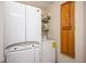 Convenient laundry area with stackable washer and dryer unit and wooden storage cabinet at 13789 Woolsey Rd, Hampton, GA 30228