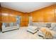 Spacious living room with beautiful wood paneling, plush sectional sofa, and bright natural light at 13789 Woolsey Rd, Hampton, GA 30228
