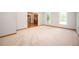 Spacious room with plush carpeting, natural light, and a glimpse of the front door and staircase at 13789 Woolsey Rd, Hampton, GA 30228