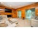 Inviting living room with wood paneling, built-in shelves, and seamless access to sunroom at 13789 Woolsey Rd, Hampton, GA 30228