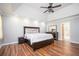 Main bedroom boasts a trey ceiling, modern ceiling fan, and hardwood floors at 13789 Woolsey Rd, Hampton, GA 30228