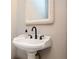 Close-up of a white pedestal sink with a decorative mirror and a black faucet at 13789 Woolsey Rd, Hampton, GA 30228