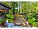 Charming backyard retreat featuring a stone patio, fire pit, mature trees, and lush landscaping at 2468 Fallview Ter, Atlanta, GA 30344