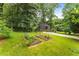 Well-maintained home exterior with raised garden beds in a lush green yard and a long driveway at 2468 Fallview Ter, Atlanta, GA 30344