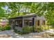 Cozy home exterior with a screened porch, yellow shutters, and beautiful landscaping at 2468 Fallview Ter, Atlanta, GA 30344