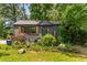 Charming home featuring a dark gray exterior, well-manicured landscaping, and eye-catching wooden window shutters at 2468 Fallview Ter, Atlanta, GA 30344