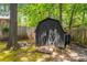 Outdoor storage shed with double doors, set amidst a wooded, fenced backyard at 2468 Fallview Ter, Atlanta, GA 30344